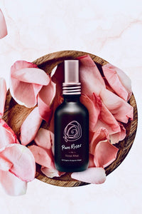 Rose Mist bottle on a wooden bowl of pink rose petals