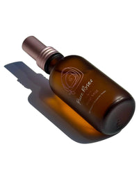 Rose Mist bottle lying on its side in sunlight with a long shadow