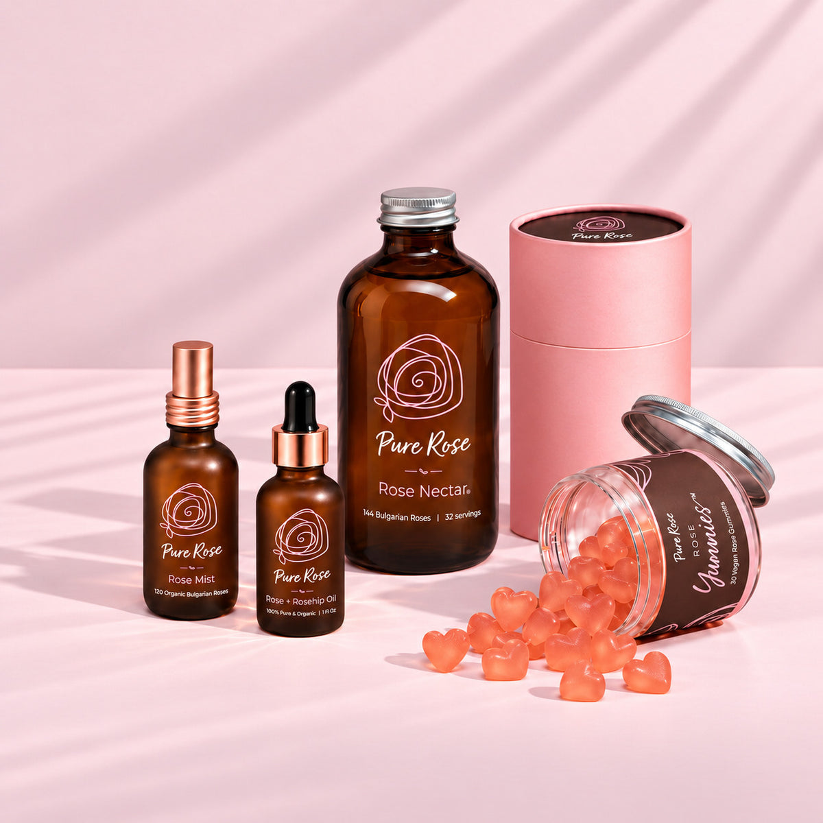 Pure Rose Trial Pack: Rose Mist, Rose + Rosehip Oil, Rose Nectar and Rose Yummies on a pale pink set